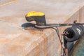 Old iron rusty bollard with one rope tied boat for marina dock Royalty Free Stock Photo