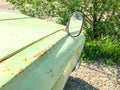 Old iron rusty car with a front mirror. Close up shot