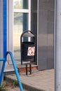 Old iron urn for garbage, sign warning not to throw burning cigarette butts inside