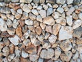 Irregular loose stone wall made of large textured brown and white limestone rocks with old twigs interwoven in the surface Royalty Free Stock Photo