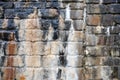 Old irregular wet stone wall with damp marks and water streaks of calcified mineral limestone beginning to form in shades of black Royalty Free Stock Photo