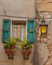 Old Italian facade window with shutters and flowers