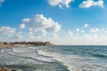 Old Jaffa city, old port and coastal line of Tel Aviv under sunset and lots of tourists are swimming and surfing at the