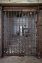 an old jail room with a broken door and toilet in the distance Royalty Free Stock Photo