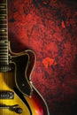 Old, jazz electric guitar on a red grunge background. Copy space. Background for music festivals, concerts. Musical education. Royalty Free Stock Photo