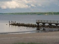 Old jetty walk on the sandy shore with a forest in the background in Eckernforde, Germany Royalty Free Stock Photo