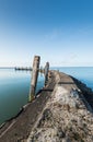 Old jetty with wooden bollards on a windless day