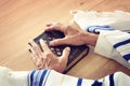 Old Jewish man hands holding a Prayer book, praying, next to tallit. Jewish traditional symbols. Rosh hashanah jewish New Year ho Royalty Free Stock Photo