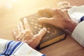 Old Jewish man hands holding a Prayer book, praying, next to tallit. Jewish traditional symbols. Rosh hashanah jewish New Year ho