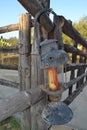 An old kerosene lamp hangs on an old wooden fence.