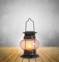 Old kerosene lantern burning with bright flame between wood Royalty Free Stock Photo