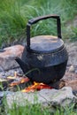 An old kettle stands on a fire in nature