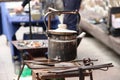 old kettle and the tools of a blacksmith at a street festival. old teapot and blacksmith tools