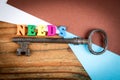 Old key and colorful letters spelling word needs on wood Royalty Free Stock Photo