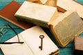 Old key, glasses and stack of antique books on blue wooden background Royalty Free Stock Photo