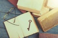 Old key, glasses and stack of antique books on blue wooden desk Royalty Free Stock Photo