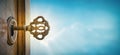 Old key in keyhole on sky background with sun ray . Concept, symbol and Idea for History, business, security background
