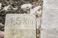 Old Kilometer stone says ` 1.5 KM.` to get into the destination. Royalty Free Stock Photo