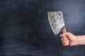 Old kitchen cleaver in the chef`s hand on a black background Royalty Free Stock Photo