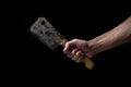 Old kitchen hatchet on a black background. A man`s hand holds a kitchen hatchet. Royalty Free Stock Photo