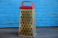 Old kitchen metal grater near the blue wall Royalty Free Stock Photo