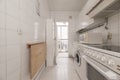 Old kitchen with mismatched white cabinets, white square tiles