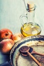 Old kitchen pan wooden spoon three onions carafe with olive oil on wooden table. Royalty Free Stock Photo