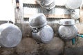 Old Kitchenware various sized metal pan pot hanging in row on hooks attached on wall galvanized sheet. Royalty Free Stock Photo