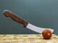 A vintage knife chopping a tomato.