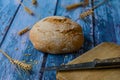 Knife on wooden cutting board. Round bread, wheat ears, grains. Royalty Free Stock Photo