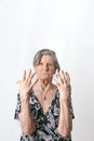 Old lady with advanced arthritis on her hands looking at the camera with serious expression over white background Royalty Free Stock Photo