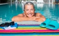 An old lady, amused, swimming to keep fit. outdoor pool with clear water and sunny day. Caucasian and smiling Royalty Free Stock Photo