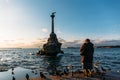 Old lady feed gulls near Sevastopol symbol - Monument to the Sunken Ships, Famous historical architecture of Crimea peninsula Royalty Free Stock Photo