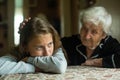 Old lady grandma comforting a crying little girl granddaughter. Helping. Royalty Free Stock Photo