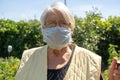 Old lady with grey hair wear protection mask, elderly woman at home on quarantine, self isolation