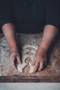 An old lady makes dumplings in a row on a table on a dark background Royalty Free Stock Photo