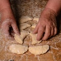 An old lady makes dumplings in a row on a table on a dark background Royalty Free Stock Photo