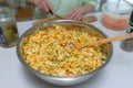 Old lady making a vegetable food in metal bowl. Cutting veggies for salad Royalty Free Stock Photo