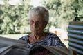 old lady reading the newspaper sitting in the garden Royalty Free Stock Photo