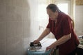 Old lady in the red blouse ironing a towel Royalty Free Stock Photo