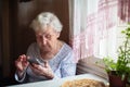 Old lady sits and typing on smartphone. Royalty Free Stock Photo