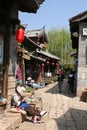 An old lady takes a nap on the cobblestone streets of Lijiang Old Town Royalty Free Stock Photo