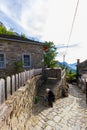 Old lady on a traditional stone-paved street, Mikro Papigko village, Epirus, Greece Royalty Free Stock Photo