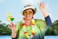 Old lady on vacation with a cocktail glass in hand