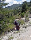 A close up of a elderly Turkish lady walking along the dirt track road