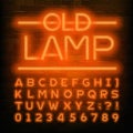 Old Lamp alphabet font. Orange neon retro letters and numbers. Brick wall background. Royalty Free Stock Photo