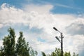 Old lamp post, tree foliage and blue sky with clouds. Day Royalty Free Stock Photo