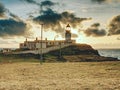 Old landscape lighthouse, white light tower with building for navigation on the thin spit of island Royalty Free Stock Photo