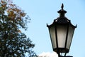 Old lantern on a background of blue sky and green trees Royalty Free Stock Photo