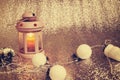 Old lantern with burning candle stands on silver background Royalty Free Stock Photo